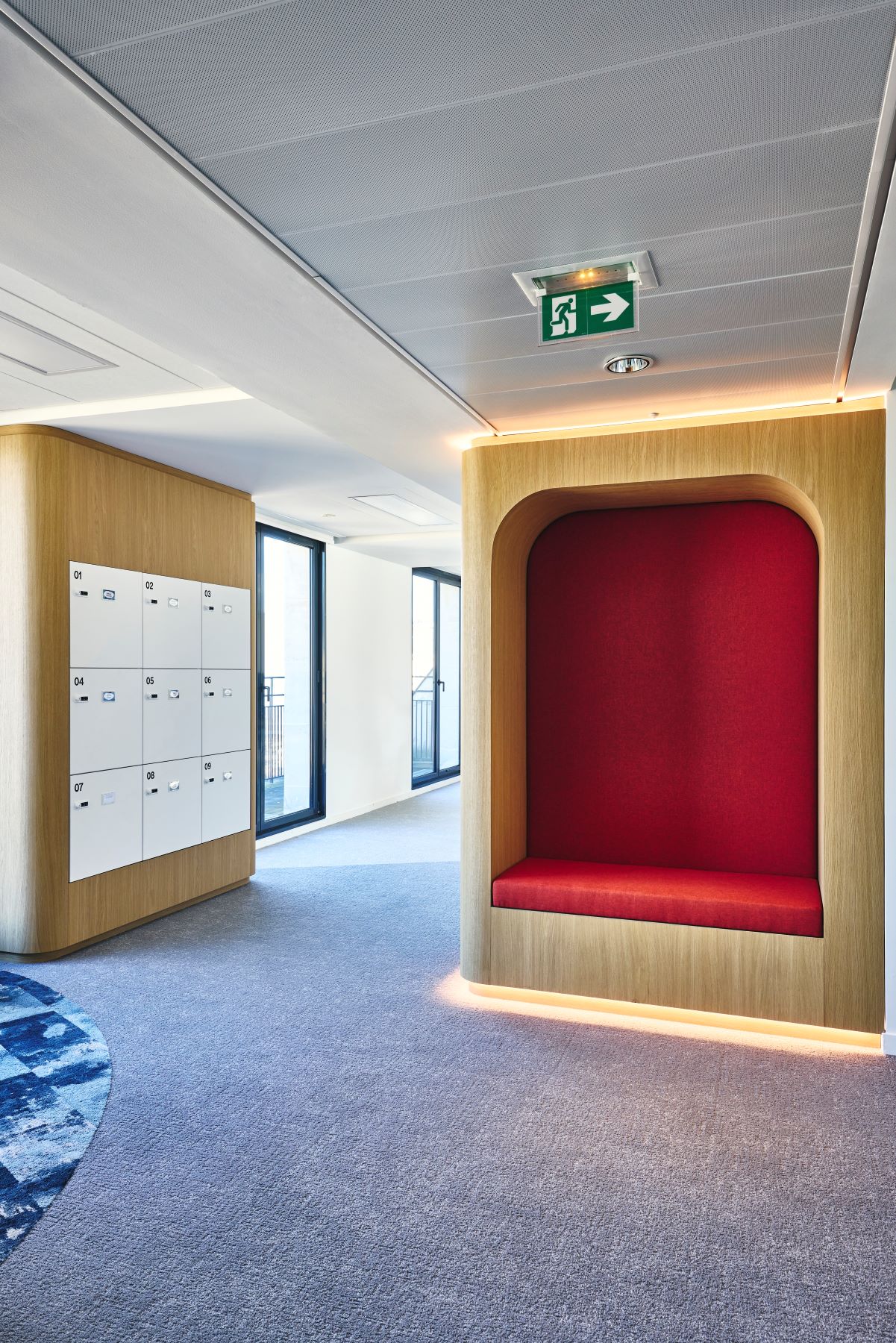 Agencement d'une alcôve rétroéclairée avec banquette intégrée chez CCR et menuiserie sur mesure pour intégration de casiers standards.