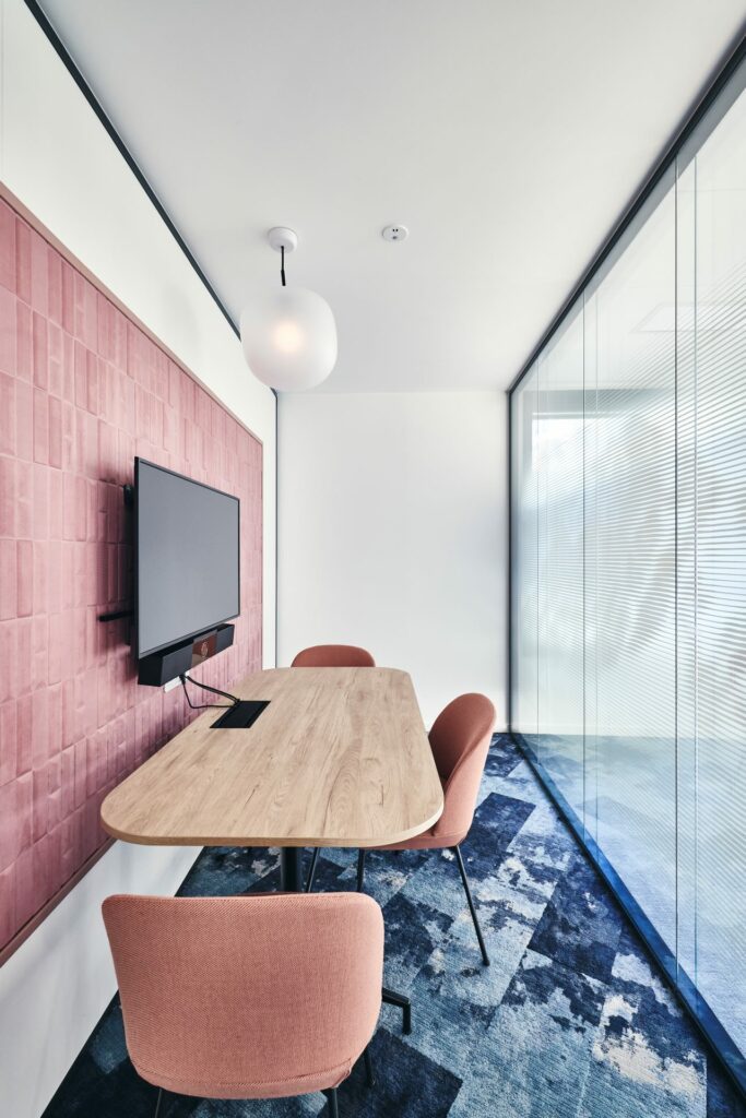 Aménagement d'un box 3 personnes chez CCR, avec table en bois, panneau acoustique, suspension luminaire globe, cloison double vitrage acoustique