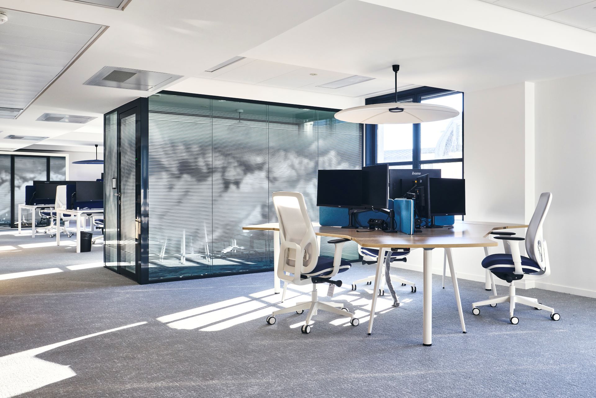 Aménagement d'un open-space chez CCR, avec bench de 3 personnes en trèfle, siège de travail ergonomique, séparateur de bureau acoustique, salle de réunion en cloison double vitrage acoustique et vitrophanie, suspension luminaire absorbeur acoustique.